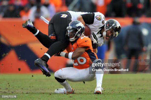 Rahim Moore of the Denver Broncos tackles Dennis Pitta of the Baltimore Ravens during the AFC Divisional Playoff Game at Sports Authority Field at...