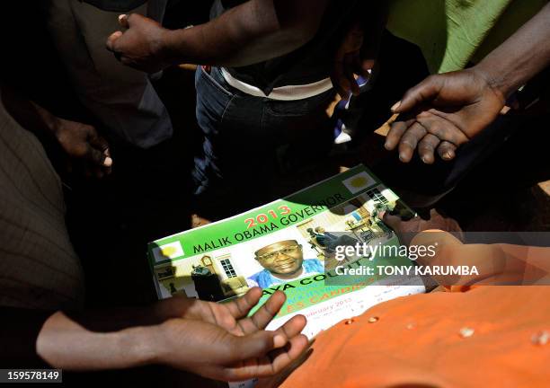 Supporter of President Barack Obama's Kenyan half brother, Malik Obama distribute campaign posters on January 16, 2013 at the peaceful hamlet of...