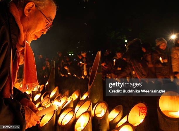 Man lights a candle for victims of the 1995 "Great Hanshin earthquake" during a memorial ceremony on January 17, 2013 in Kobe, Japan. Memorial...