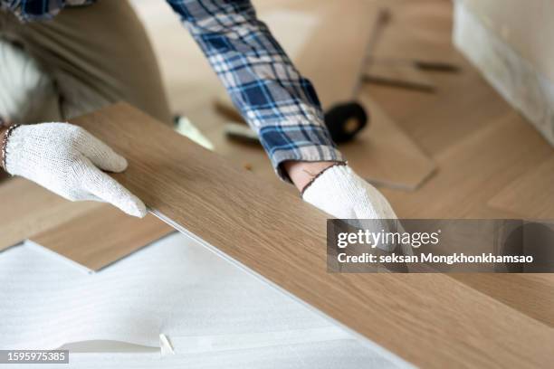 man laying finished parquet flooring, close-up - parqué fotografías e imágenes de stock