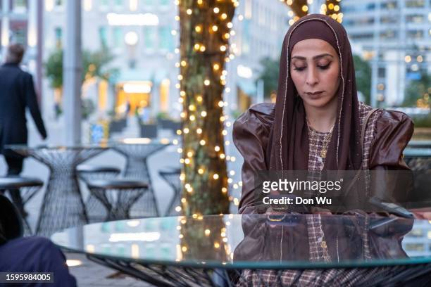 middle eastern woman using mobile phone - north african culture stock pictures, royalty-free photos & images