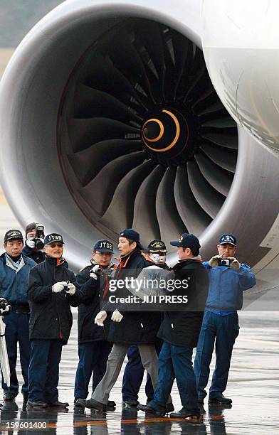 Japanese aviation expert carries a battery, which leaked electrolyte, out of a All Nippon Airways Boeing 787 Dreamlier plane at Takamatsu airport in...