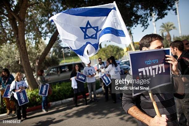 Supporters of former Israeli foreign minister Tzipi Livni, the leader of new party, The Movement, wave flags and hold placards ahead of an election...