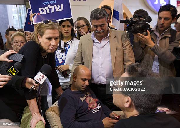 Chairperson of The Movement party and former Israeli foreign minister Tzipi Livni speaks with Israeli men during an election campaign event at the...