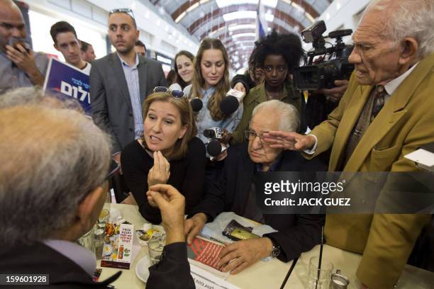 Chairperson of The Movement party and former Israeli foreign minister Tzipi Livni chats with men during an election campaign event at the Ayalon Mall...
