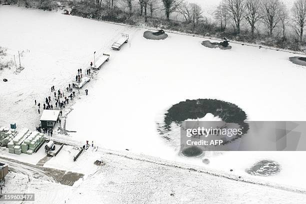 An helicopter flies low above the Veluwemeer, a lake in central Holland, on January 17, 2013. The helicopter is hired by skating-clubs situated along...