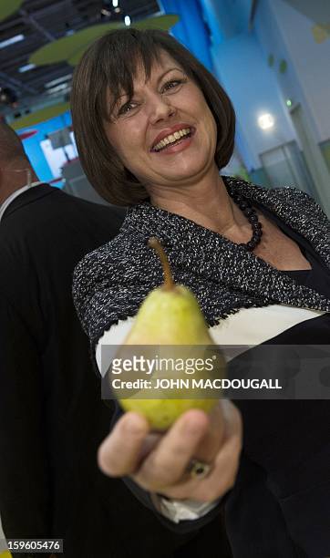 German Agriculture Minister Ilse Aigner holds up a pear as she tours the German agriculture ministry's hall at the Gruene Woche Agricultural Fair in...