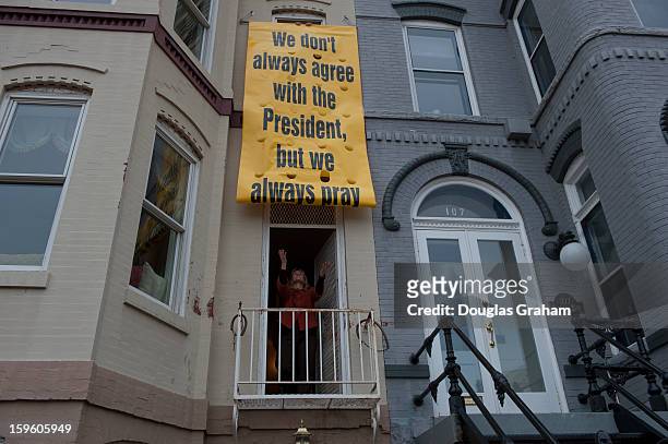 Jan 17 : Peggy Nienaber catches a banner as it unfurls at the Faith and Action building. Clergy leaders put the banner up today on their building a...