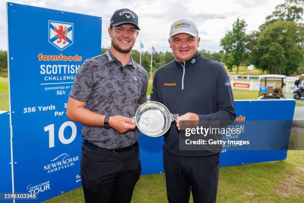 Sam Bairstow of England receives the trophy from Paul Lawrie following his one stroke victory during Day Four of the Farmfoods Scottish Challenge...