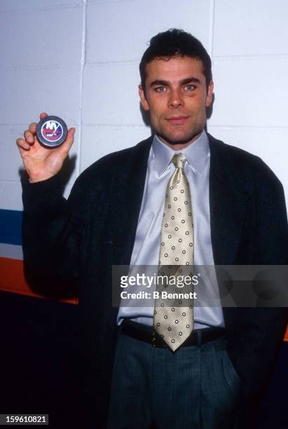 Adam Oates of the Washington Capitals holds up the puck that he got his 1000th career point against the New York Islanders on October 8, 1997 at the...