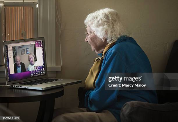 Senior woman Skypeing with friends on a laptop.