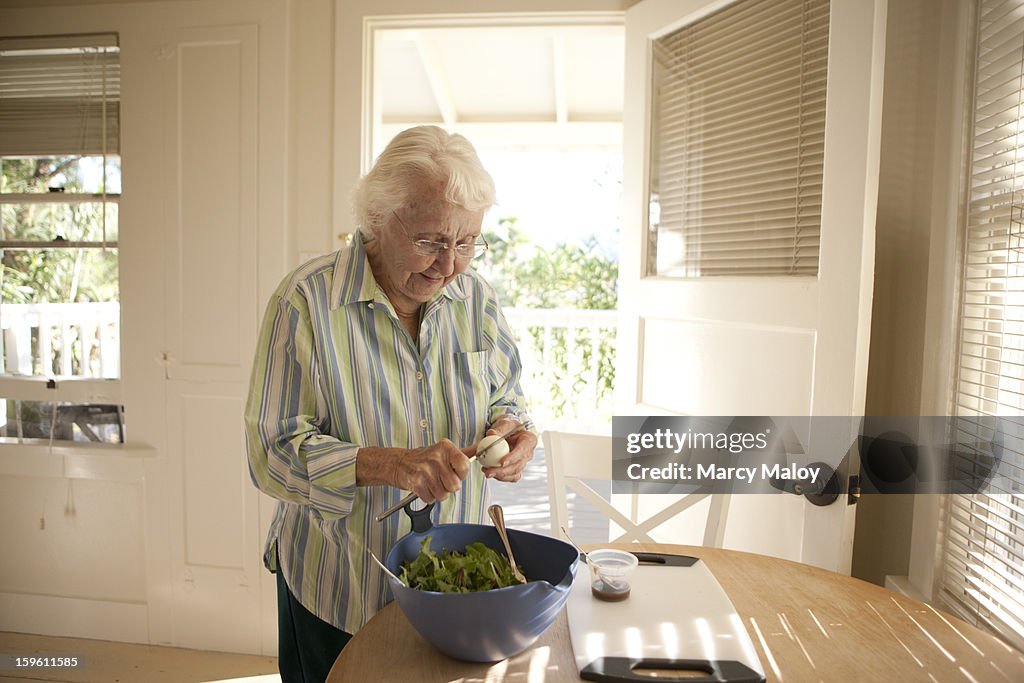 Senior woman preparing a salad.