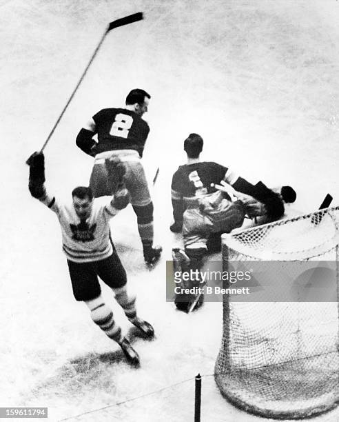 Syl Apps of the Toronto Maple Leafs scores past goalie Jim Henry and Art Coulter of the New York Rangers during Game 1 of the 1942 Semi-Finals on...