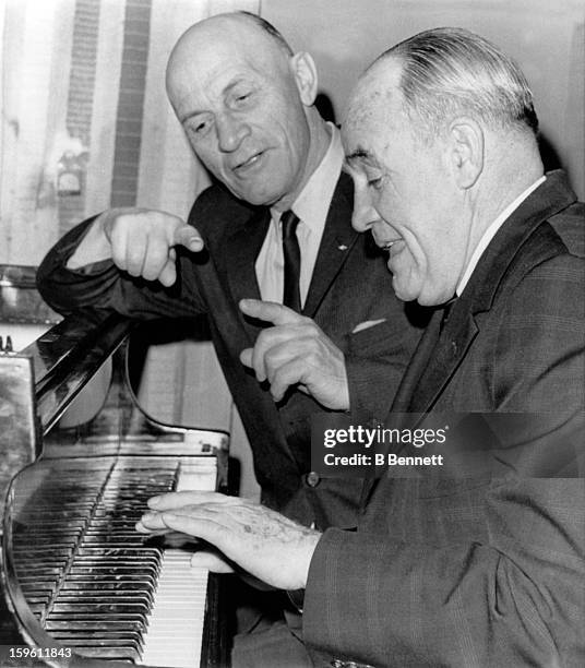 Hall of Famer and former Boston Bruins player Eddie Shore conducts, as Frank "King" Clancy, assistant general manager of the Toronto Maple Leafs,...