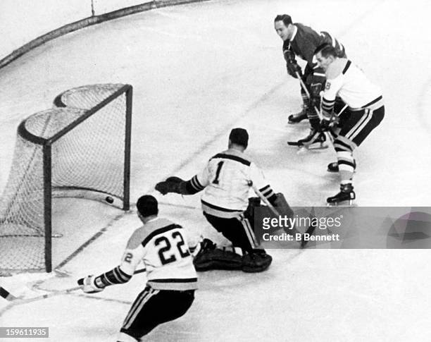 Red Kelly of the Toronto Maple Leafs scores on goalie Eddie Johnston of the Boston Bruins as Bob Woytowich of the Bruins and Bob Dillabough defend...