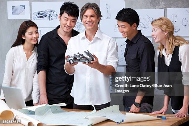 car designers studying a model car - car designer stock pictures, royalty-free photos & images