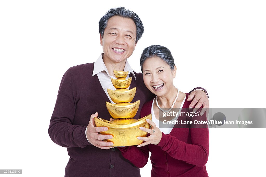 Happy senior couple with Chinese gold ingot