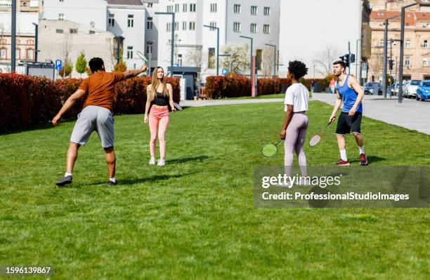 a happy multi-ethnic friends are enjoying playing badminton in nature. - shuttlecock 個照片及圖片檔