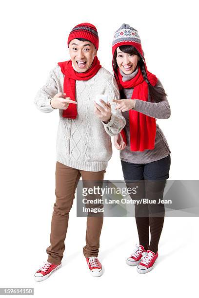 lovely young couple with smart phone in chinese new year - knit hat stock pictures, royalty-free photos & images