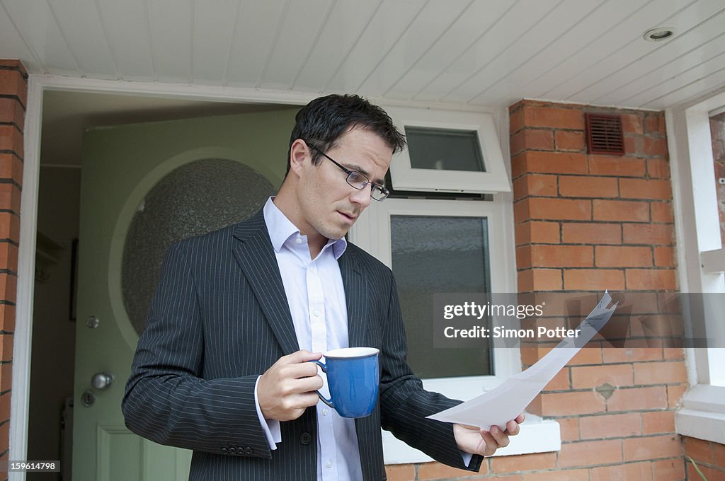 Businessman reading with cup of coffee