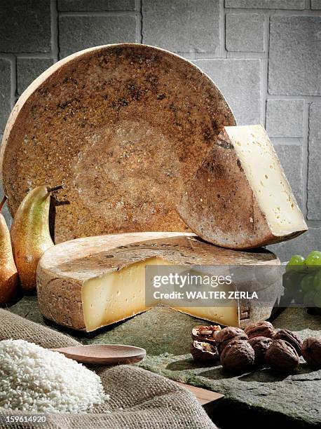 cheese, fruit and grains on table - fontina cheese wedge stock pictures, royalty-free photos & images