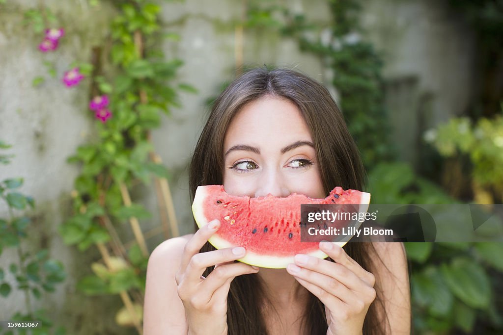 Smiling woman playing with watermelon