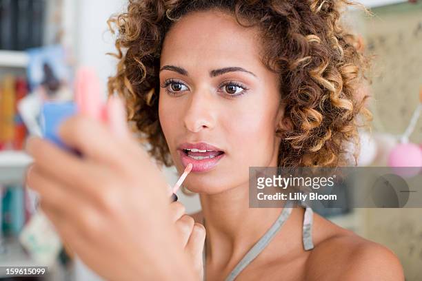 woman applying make up in mirror - shiny lips stock pictures, royalty-free photos & images