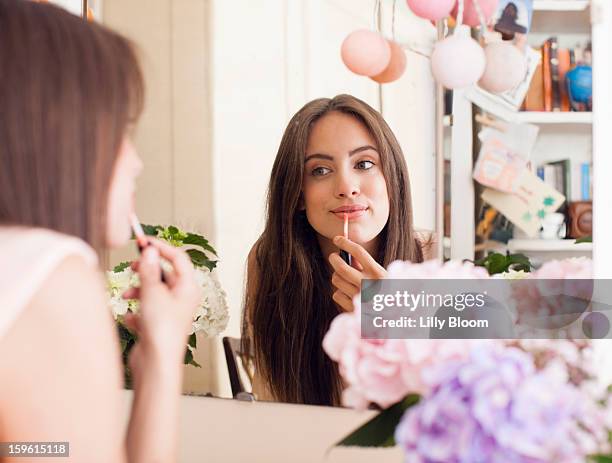 woman applying make up in mirror - lipgloss bildbanksfoton och bilder