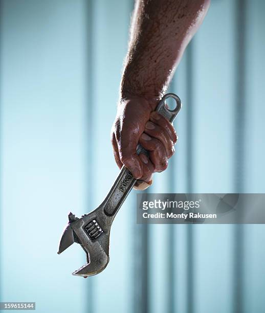 man holding adjustable spanner with oil dripping - adjustable wrench stock pictures, royalty-free photos & images