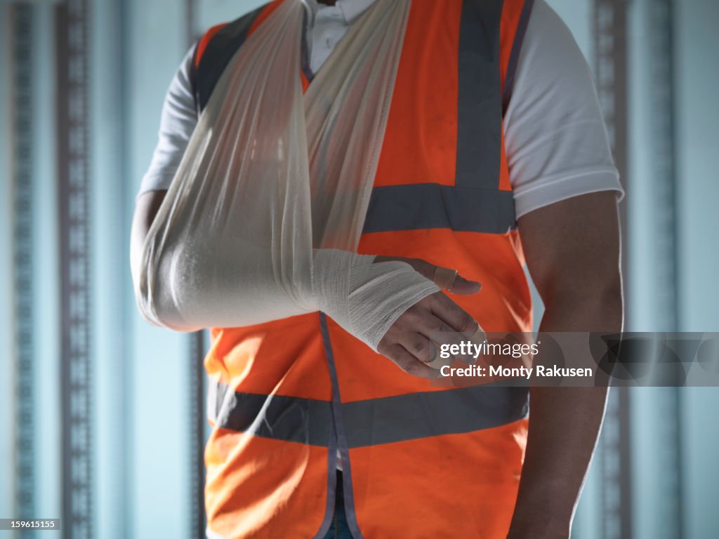 Man wearing high visibility jacket with bandaged arm in sling