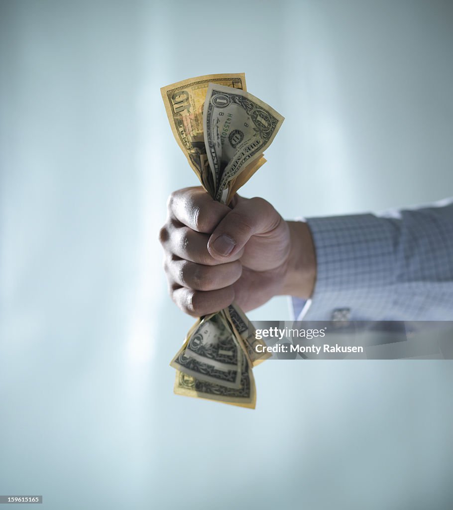 Man holding fistful of US dollar bills