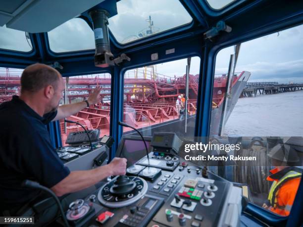 captain steering tug out at sea, view of ships bridge and view through window - ship's bridge imagens e fotografias de stock