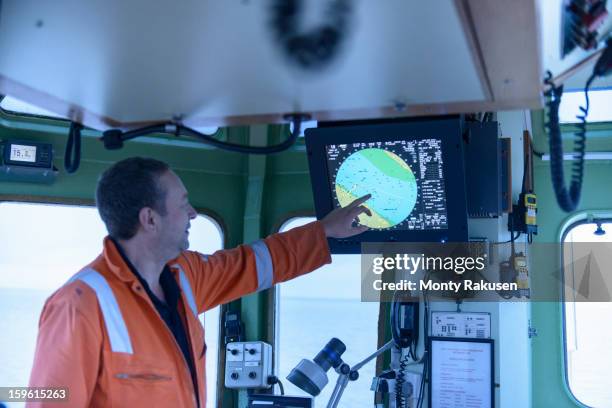 ships mate pointing at digital chart on monitor on tug - boat gps stockfoto's en -beelden