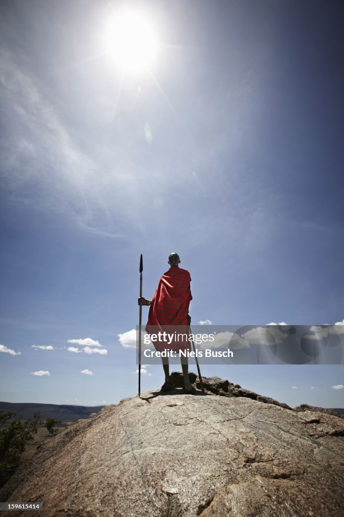 Maasai man standing on top of rock