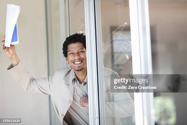 businessman leaning in glass door - curly waves stock pictures, royalty-free photos & images