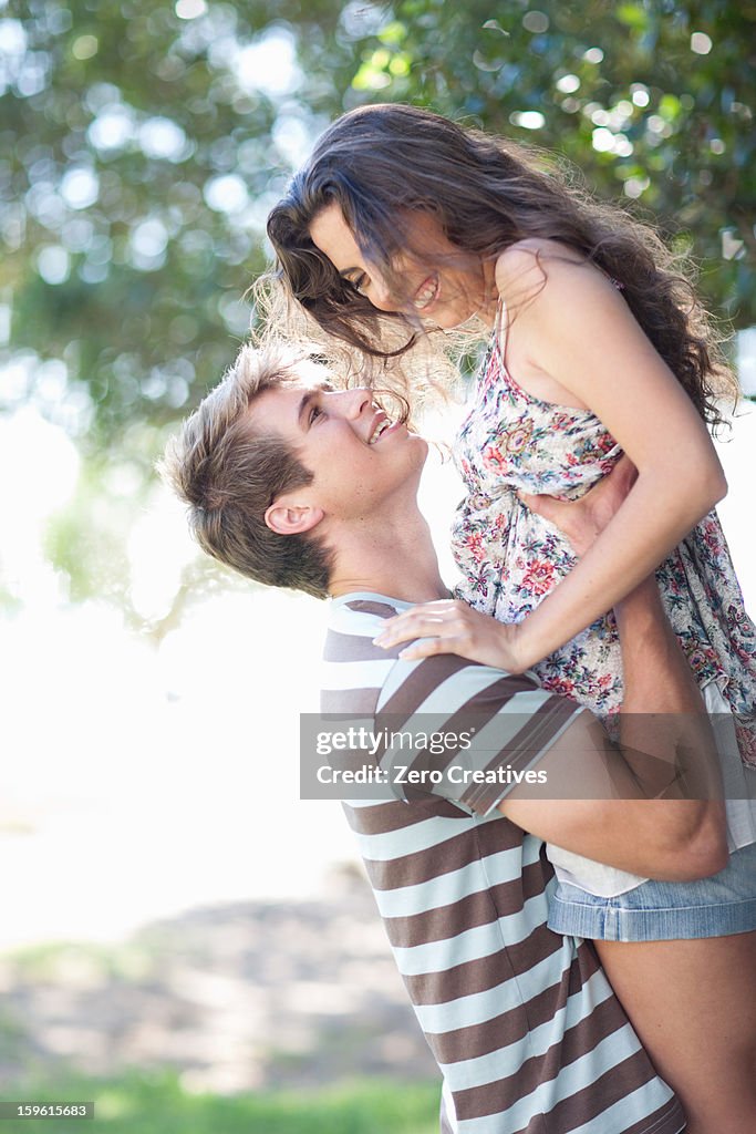 Man lifting girlfriend outdoors