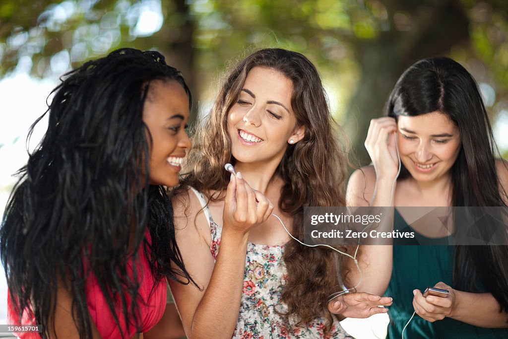 Women listening to earphones outdoors