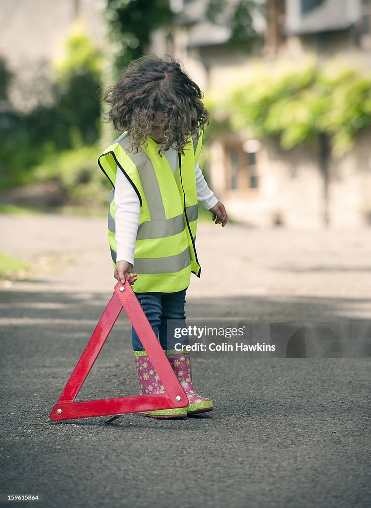 Girl playing traffic worker on rural road