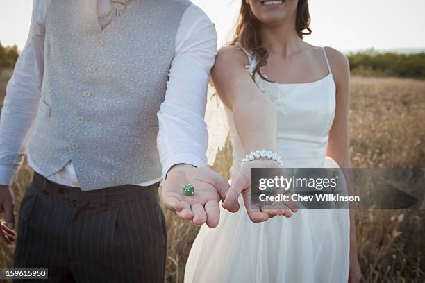 newlywed couple holding green dice - newlywed game stock pictures, royalty-free photos & images