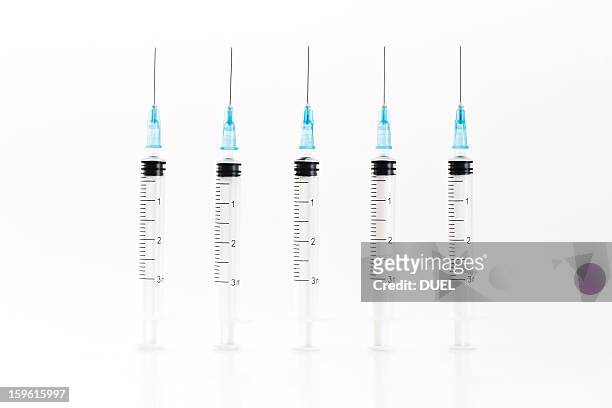 row of blue syringes - injection stock-fotos und bilder