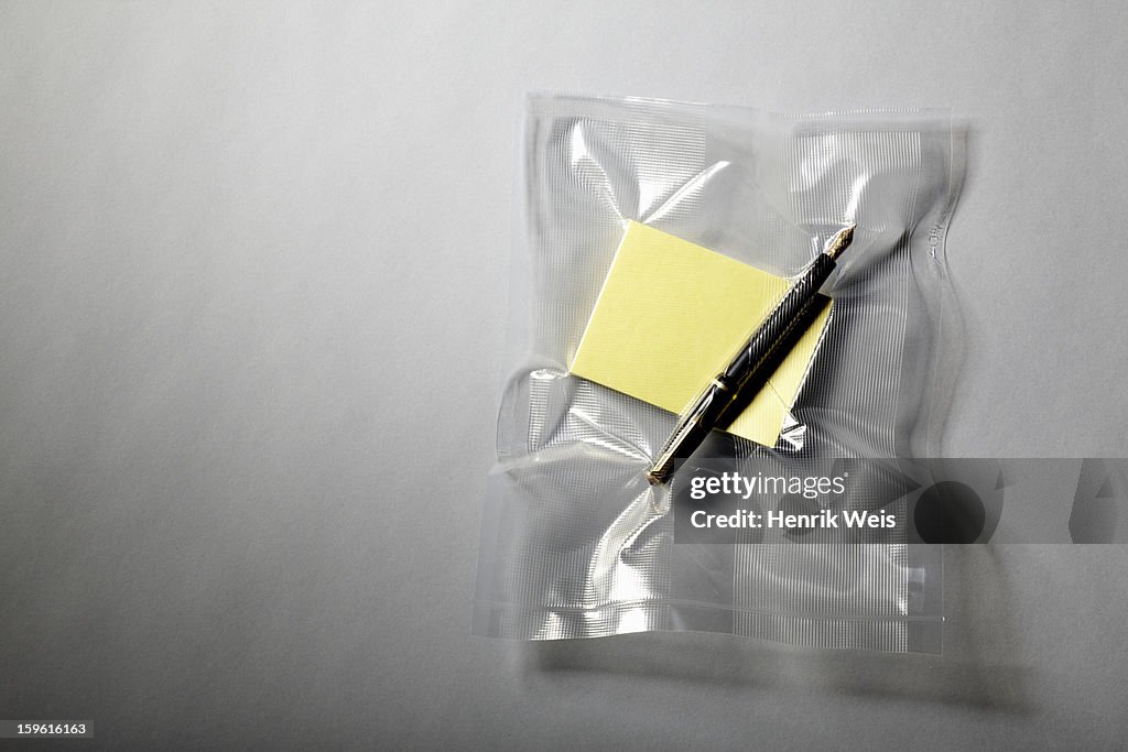 Pen and paper shrink wrapped in plastic