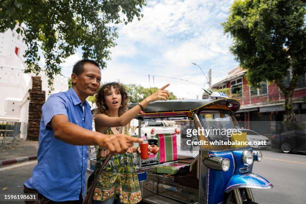 young asian girl asks for directions in thailand and asks tuk tuk drivers for help - tourist asking stock pictures, royalty-free photos & images
