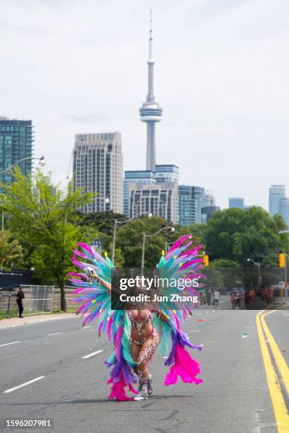 toronto 2023 caribbean carnival or caribana: female dancer with large feather wings under cn tower - caribbean culture stock pictures, royalty-free photos & images