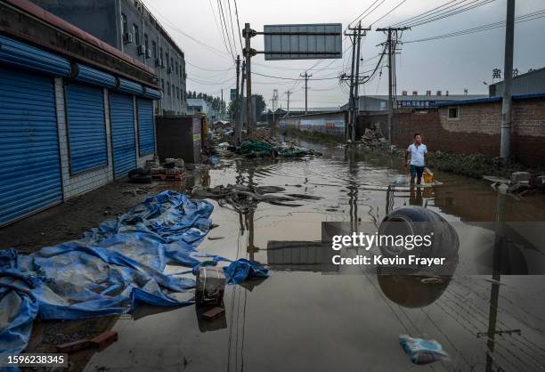 Man wades through receding floodwaters on August 5, 2023 in a street in Zhuozhou, Hebei Province south of Beijing, China. The extreme rainfall from...