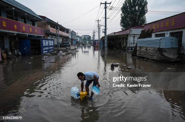 Man wades through receding floodwaters on August 5, 2023 in a street in Zhuozhou, Hebei Province south of Beijing, China. The extreme rainfall from...