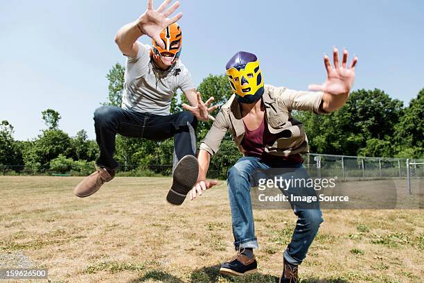 two young men wearing wrestling masks - teenager man mischievous stock pictures, royalty-free photos & images