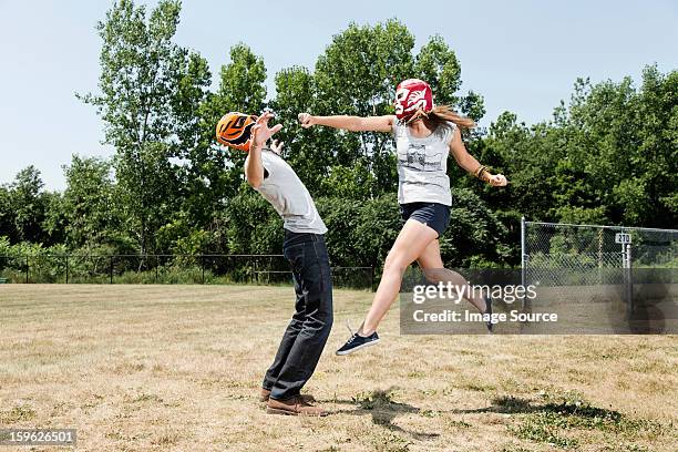 couple wearing wrestling masks play fighting - girls wrestling stockfoto's en -beelden