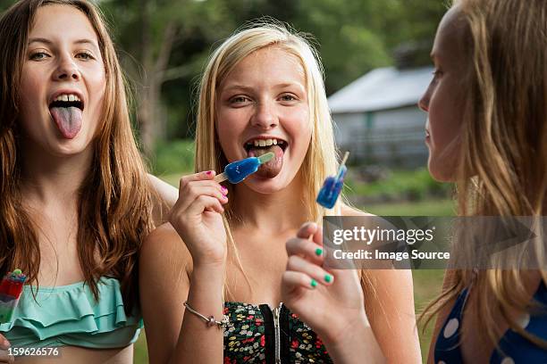 girls eating ice lollies - girls licking girls stockfoto's en -beelden