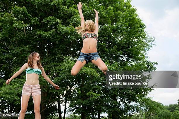 two girls on trampoline - 13 year old girls in shorts stock pictures, royalty-free photos & images