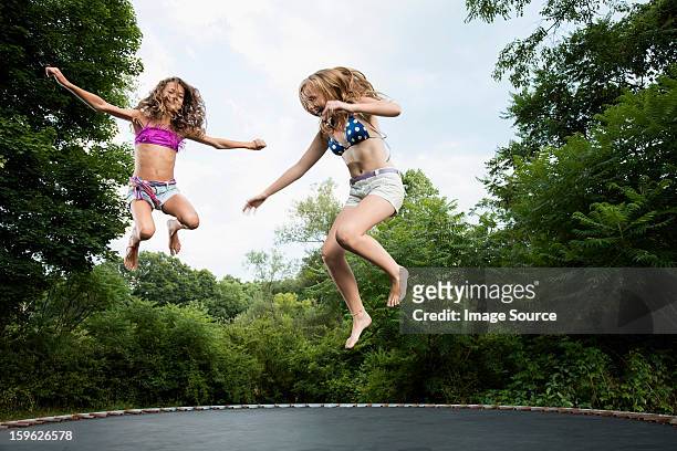two girls on trampoline - trampoline stock pictures, royalty-free photos & images